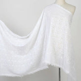 White cotton eyelet fabric with delicate floral embroidery, breathable and lightweight.