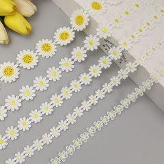 Close-up of yellow embroidered daisy flower lace trim showing intricate floral embroidery and soft texture