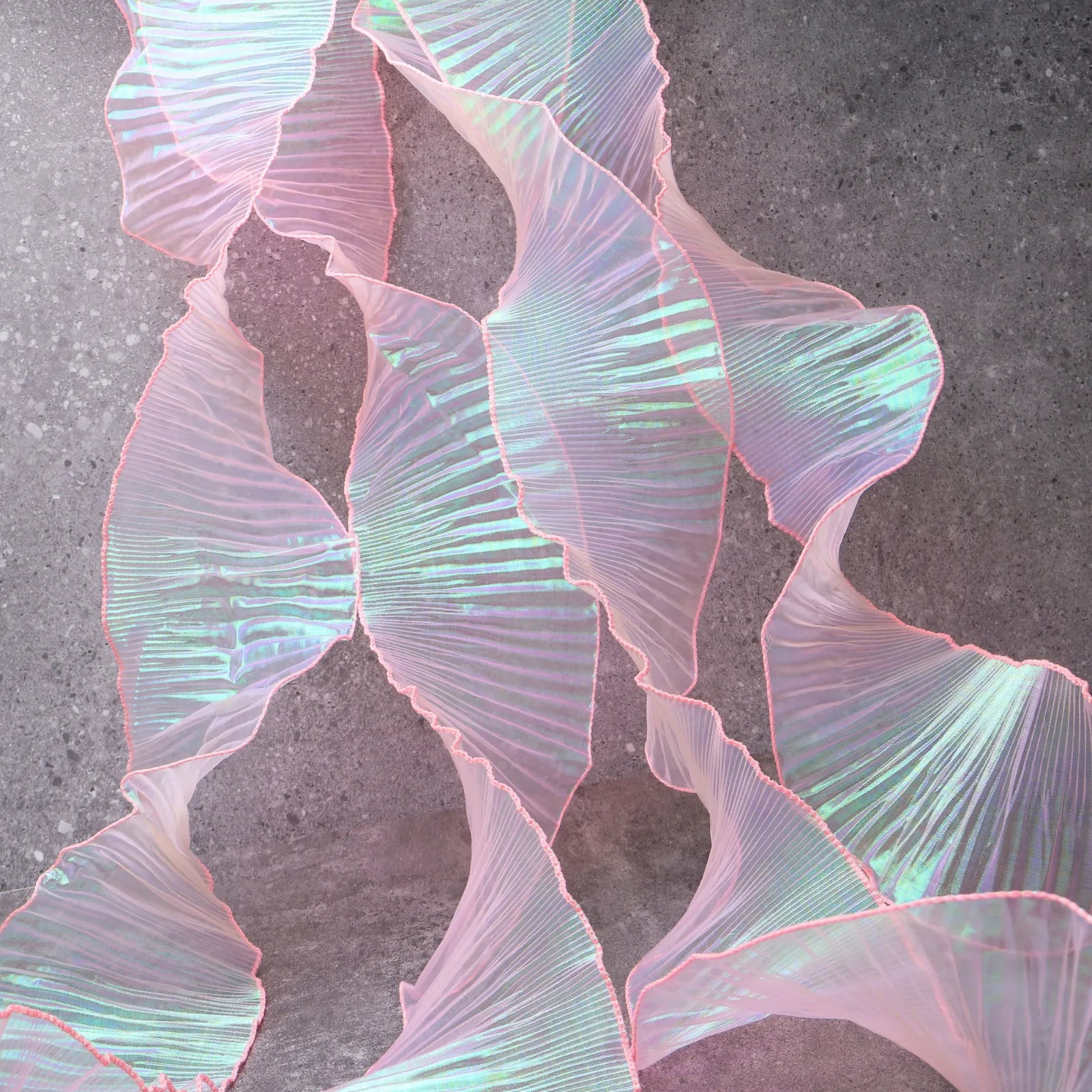 Detail of Iridescent Chiffon Ruffle Trim texture in Pink, perfect for costumes, sewing, and crafts